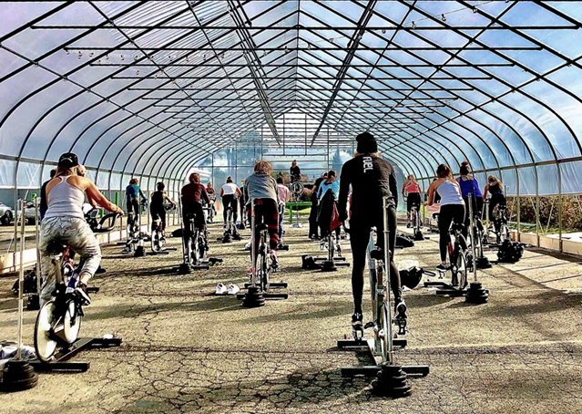 USA: Spinning in a poly film greenhouse: studio holds outdoor classes in greenhouse